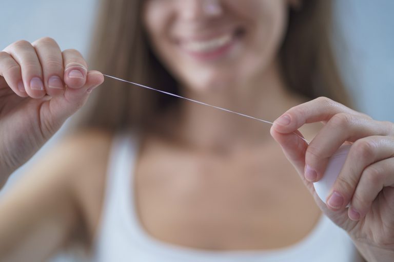 Woman holding a strand of dental floss