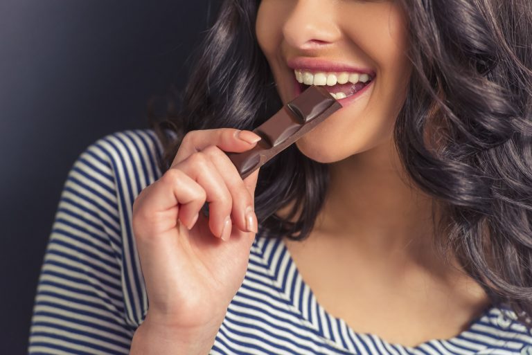 Female eating chocolate and smiling