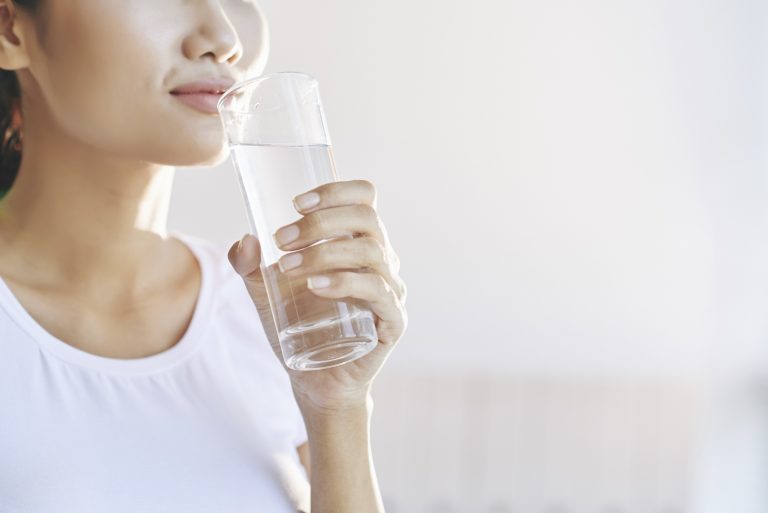 Female holding a glass of water near her mouth