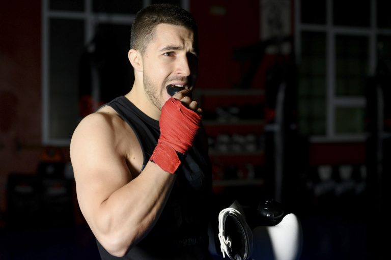 Boxing fighter putting on mouthguard