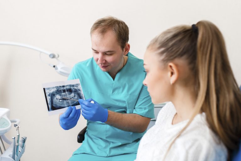 Dentist showing an x-ray of a patient's teeth to the patient