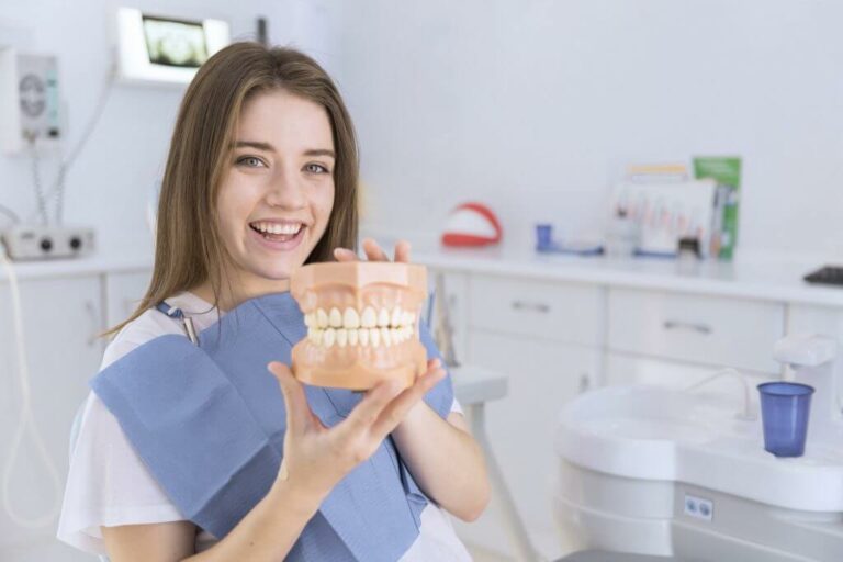 dental patient holding a tooth model to promote national dental hygiene month