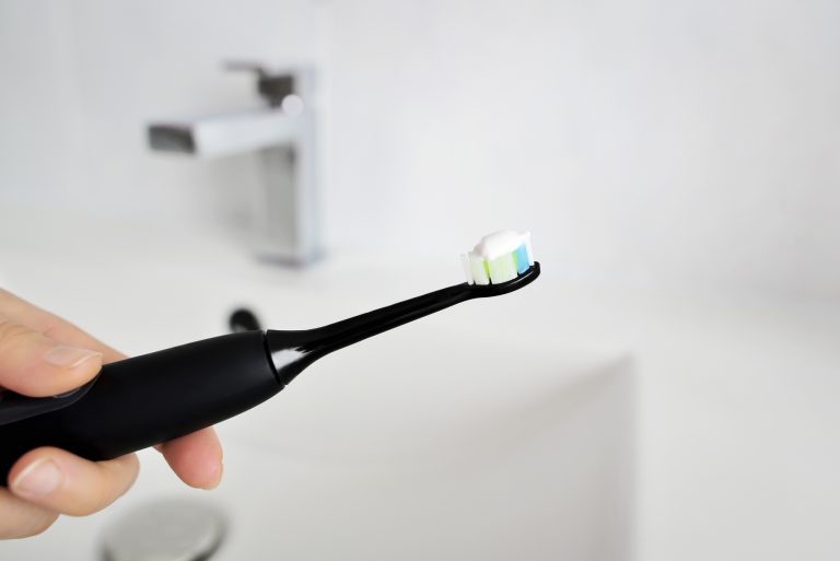 Black toothbrush with toothpaste on it